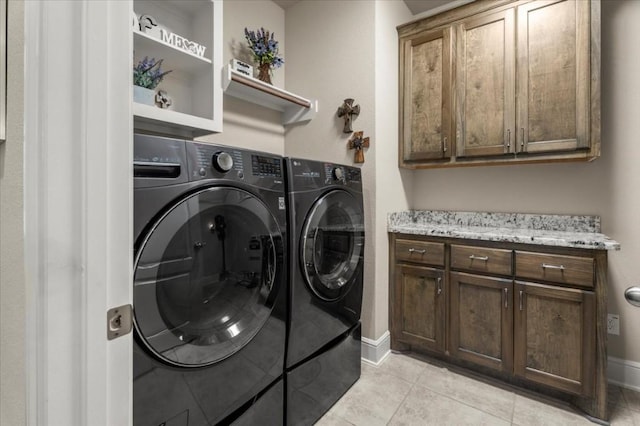 laundry area featuring cabinet space, washing machine and clothes dryer, light tile patterned flooring, and baseboards