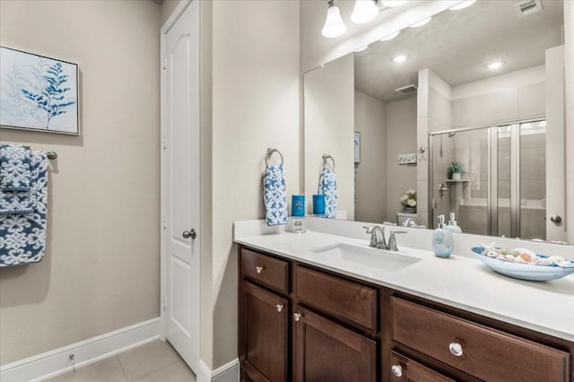 bathroom with a stall shower, tile patterned floors, baseboards, vanity, and toilet