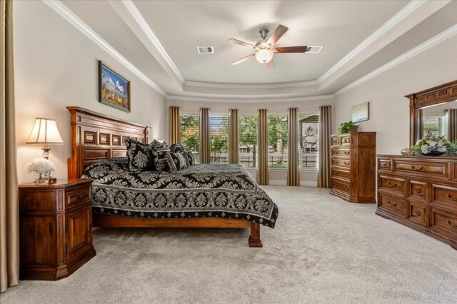 bedroom featuring light colored carpet, a raised ceiling, crown molding, and ceiling fan