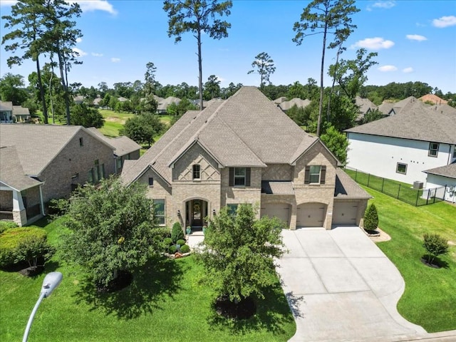 french country inspired facade featuring concrete driveway, brick siding, stone siding, an attached garage, and a shingled roof