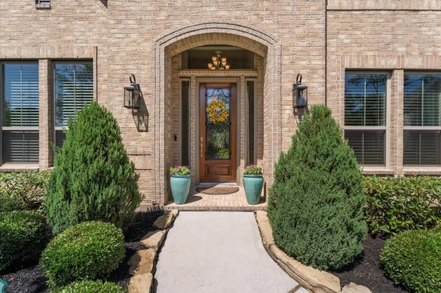 view of exterior entry featuring brick siding