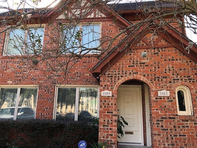 view of exterior entry with brick siding