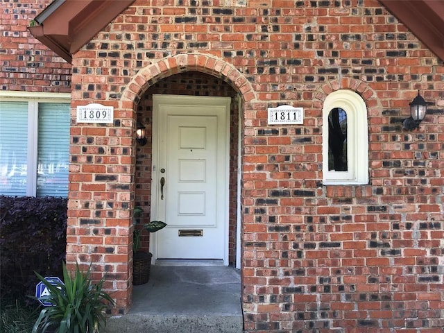 property entrance featuring brick siding