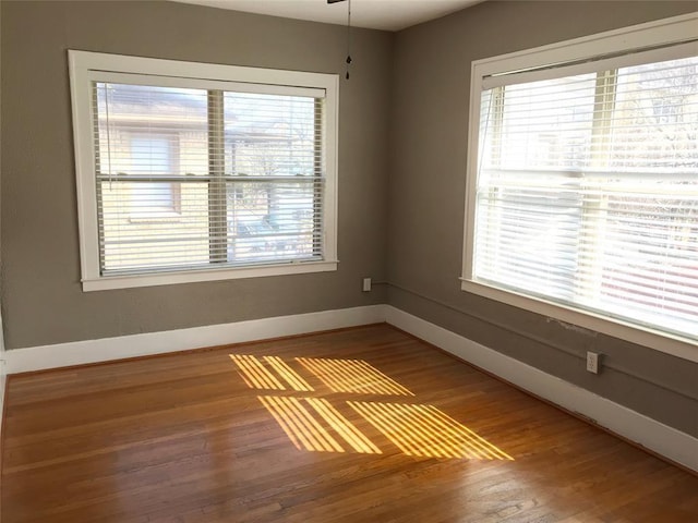 empty room with baseboards and wood finished floors