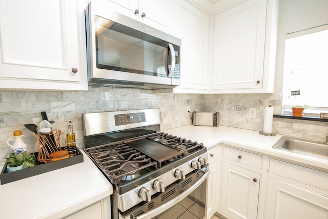 11606 Curry Ridge Ln, Tomball, TX 77377 - kitchen with stainless steel appliances, backsplash, white cabinetry, and a sink