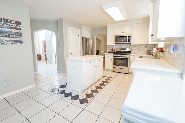 11606 Curry Ridge Ln, Tomball, TX 77377 - kitchen featuring appliances with stainless steel finishes, a sink, arched walkways, and light tile patterned floors
