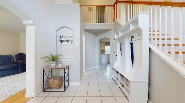 11606 Curry Ridge Ln, Tomball, TX 77377 - mudroom with arched walkways, light tile patterned flooring, baseboards, and a high ceiling
