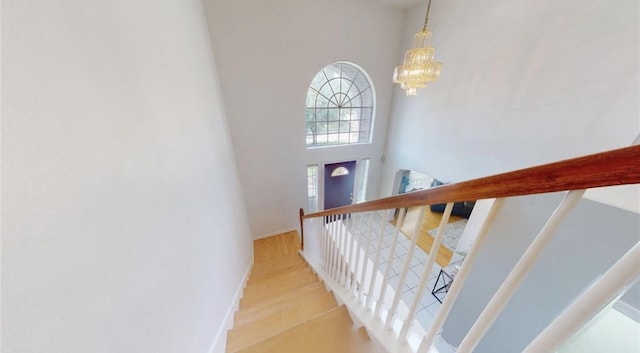 11606 Curry Ridge Ln, Tomball, TX 77377 - staircase featuring a towering ceiling, baseboards, a chandelier, and wood finished floors