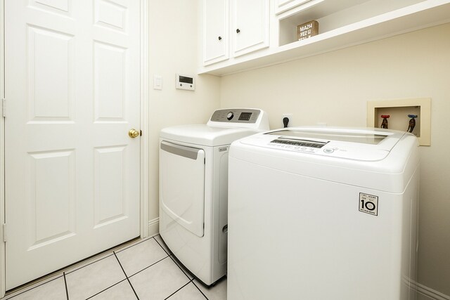 11606 Curry Ridge Ln, Tomball, TX 77377 - laundry room featuring cabinet space, washing machine and dryer, and light tile patterned floors