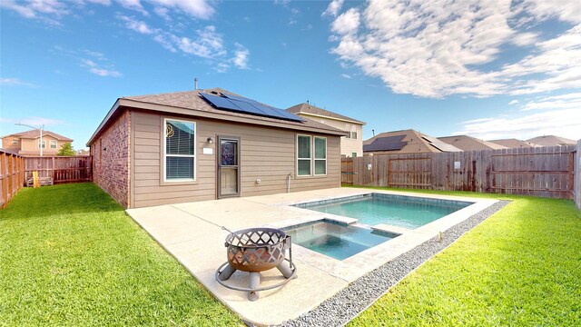 19015 Buckley Oak Dr, New Caney, TX 77357 - back of property with roof mounted solar panels, a patio, and a pool with connected hot tub