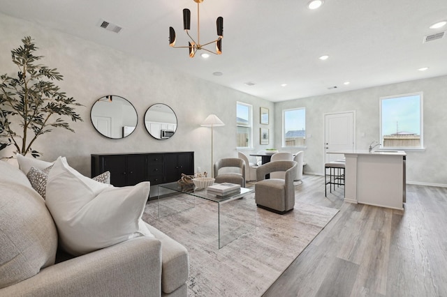 16602 Bobal Path, Houston, TX 77090 - living room featuring light wood-type flooring, healthy amount of natural light, recessed lighting, a chandelier, and baseboards