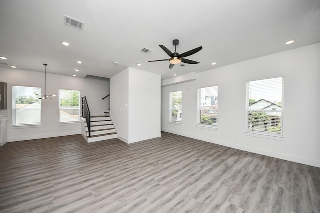 unfurnished living room with stairway, wood finished floors, baseboards, recessed lighting, and ceiling fan