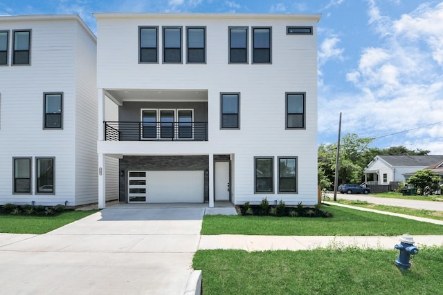 view of front facade with concrete driveway, a front yard, a balcony, and an attached garage