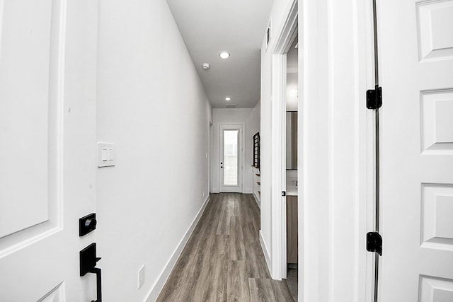 corridor featuring wood finished floors, baseboards, and recessed lighting