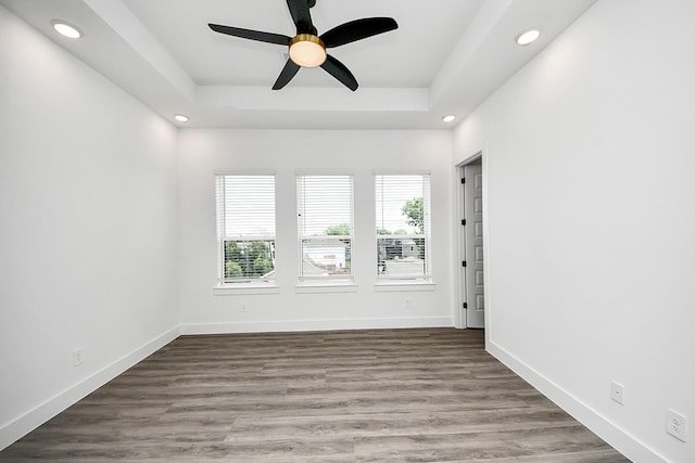 unfurnished room with recessed lighting, a raised ceiling, ceiling fan, baseboards, and wood finished floors