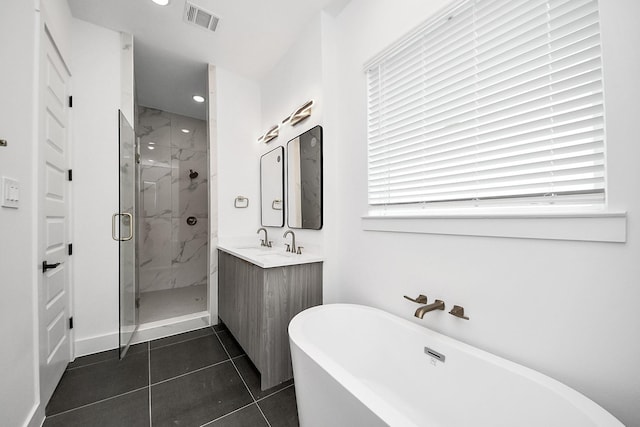 bathroom with a marble finish shower, a freestanding bath, vanity, healthy amount of natural light, and recessed lighting