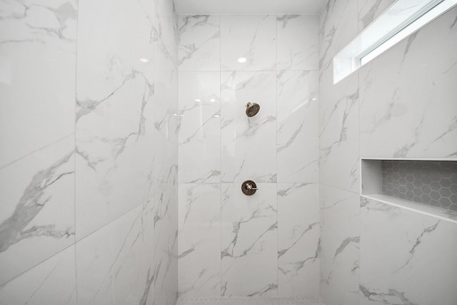 bathroom featuring a marble finish shower