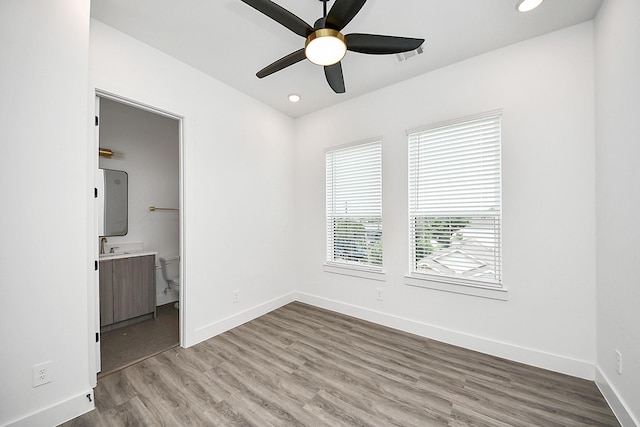 unfurnished bedroom with light wood finished floors, baseboards, recessed lighting, connected bathroom, and ceiling fan