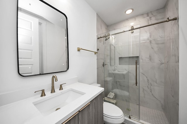 bathroom with toilet, a marble finish shower, vanity, and recessed lighting