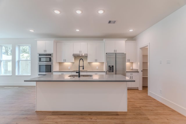 3203 Hemingway Dr, Montgomery, TX 77356 - kitchen with appliances with stainless steel finishes, a sink, white cabinets, under cabinet range hood, and recessed lighting