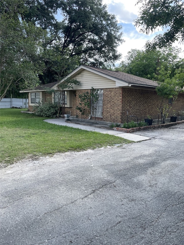 single story home with brick siding and a front yard