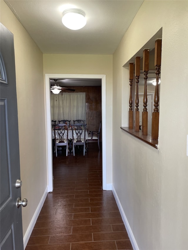 hall featuring baseboards and dark wood-style floors