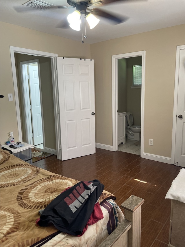 bedroom featuring wood tiled floors, baseboards, and ensuite bath