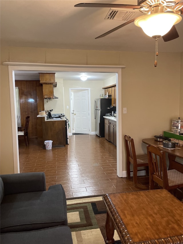 living area featuring a ceiling fan and baseboards