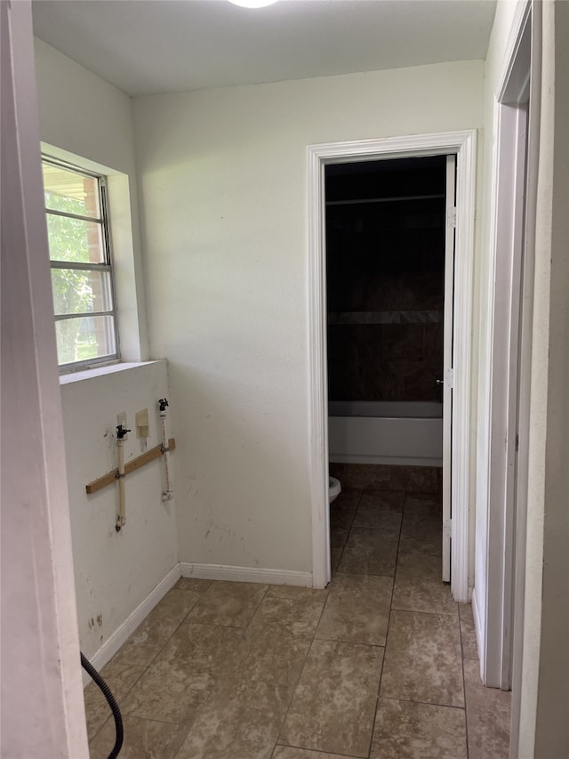 bathroom with toilet, tile patterned floors, and baseboards