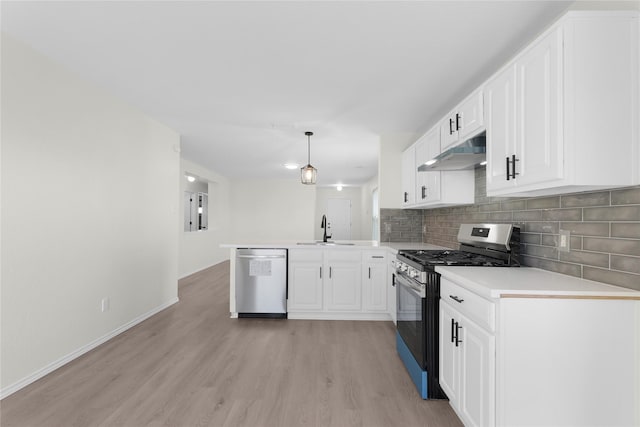 11339 Log Cabin Ln, Tomball, TX 77375 - kitchen featuring appliances with stainless steel finishes, under cabinet range hood, a sink, a peninsula, and light wood-style flooring