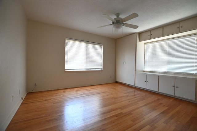 spare room with plenty of natural light, light wood-type flooring, and a ceiling fan