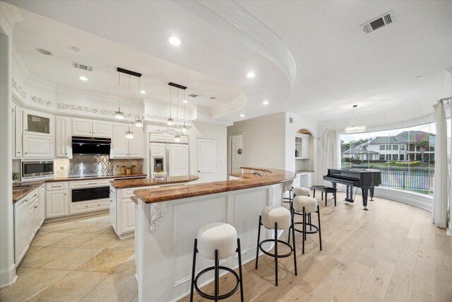 22 Berenger Pl, Sugar Land, TX 77479 - kitchen with a large island, built in appliances, under cabinet range hood, crown molding, and wood counters