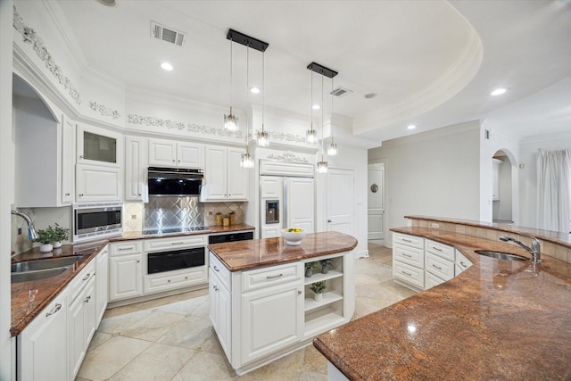 22 Berenger Pl, Sugar Land, TX 77479 - kitchen with a sink, a large island with sink, built in appliances, ornamental molding, and a warming drawer