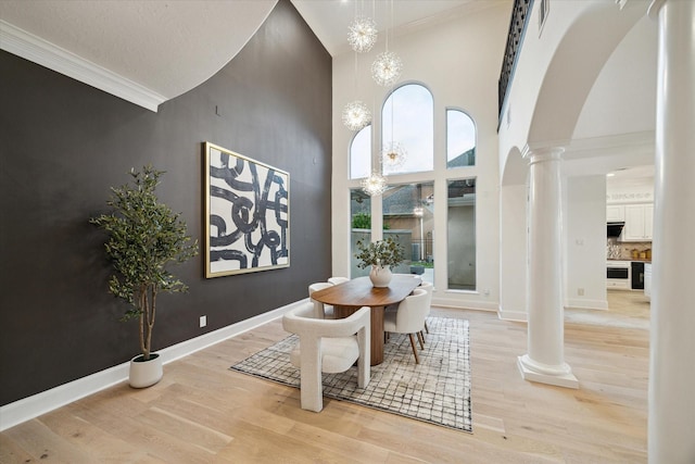 22 Berenger Pl, Sugar Land, TX 77479 - dining room with ornate columns, a towering ceiling, ornamental molding, light wood finished floors, and arched walkways