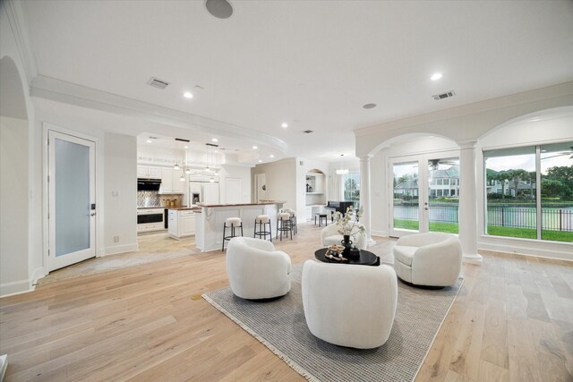 22 Berenger Pl, Sugar Land, TX 77479 - living area featuring arched walkways, decorative columns, ornamental molding, light wood finished floors, and recessed lighting