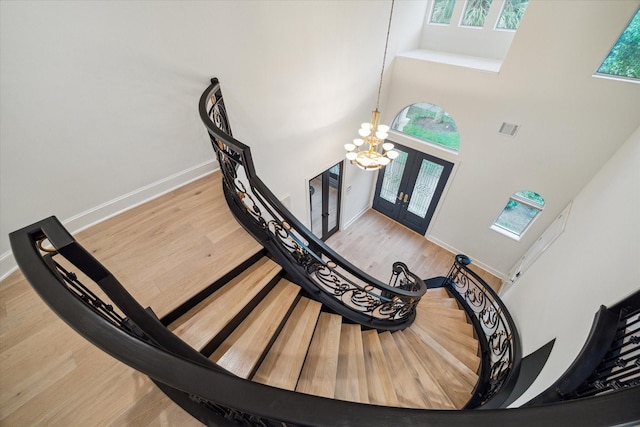 22 Berenger Pl, Sugar Land, TX 77479 - staircase featuring a towering ceiling, french doors, baseboards, wood finished floors, and a chandelier