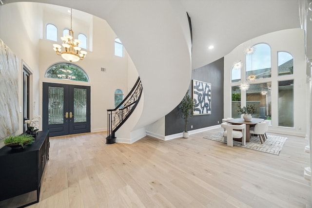 22 Berenger Pl, Sugar Land, TX 77479 - entrance foyer with a chandelier, a high ceiling, arched walkways, hardwood / wood-style flooring, and french doors