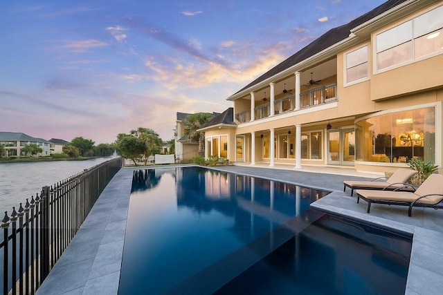 22 Berenger Pl, Sugar Land, TX 77479 - pool at dusk with ceiling fan, a patio, and a water view