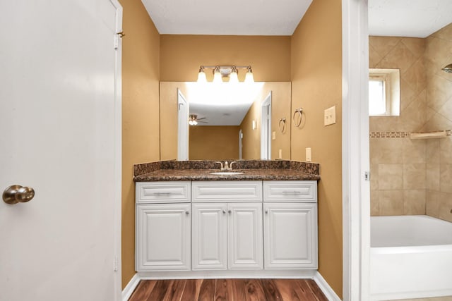 bathroom with ceiling fan, wood finished floors, vanity, and baseboards