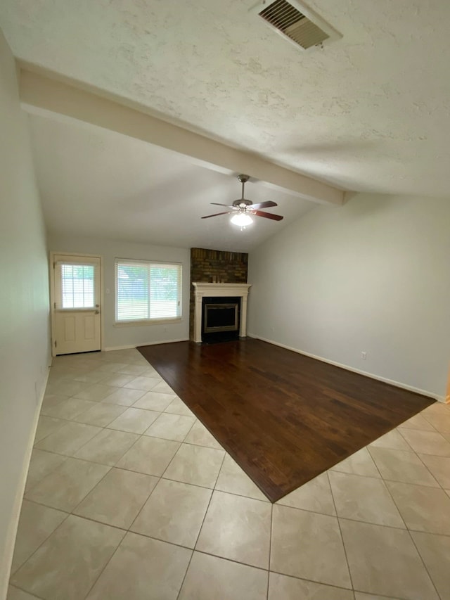 13430 Firebrick Dr, Houston, TX 77041 - unfurnished living room with tile patterned flooring, ceiling fan, a fireplace, a textured ceiling, and baseboards