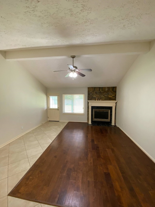 13430 Firebrick Dr, Houston, TX 77041 - unfurnished living room with ceiling fan, a large fireplace, hardwood / wood-style floors, baseboards, and a textured ceiling