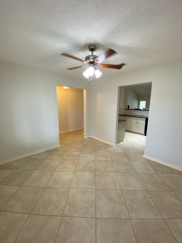 13430 Firebrick Dr, Houston, TX 77041 - spare room with ceiling fan, a textured ceiling, light tile patterned floors, and baseboards