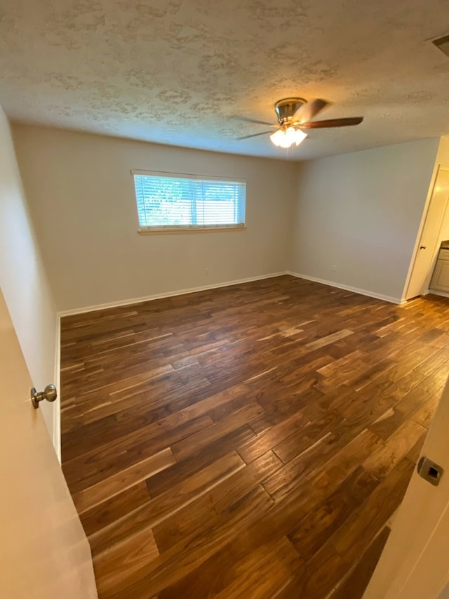 13430 Firebrick Dr, Houston, TX 77041 - spare room featuring dark wood-style flooring, ceiling fan, a textured ceiling, and baseboards