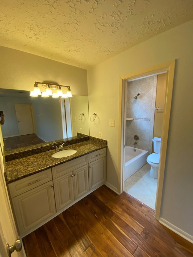 13430 Firebrick Dr, Houston, TX 77041 - full bath featuring toilet, wood finished floors, a textured ceiling, vanity, and bathing tub / shower combination