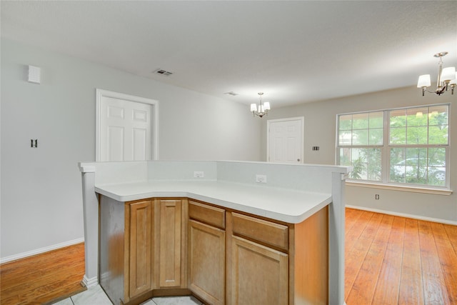 12409 Urban Dale Ct, Houston, TX 77082 - kitchen featuring a chandelier, baseboards, light wood finished floors, light countertops, and hanging light fixtures