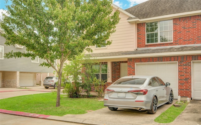12409 Urban Dale Ct, Houston, TX 77082 - view of front facade featuring brick siding, roof with shingles, a garage, driveway, and a front lawn
