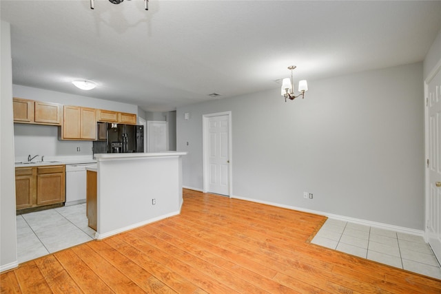 12409 Urban Dale Ct, Houston, TX 77082 - kitchen featuring black fridge, a chandelier, white dishwasher, a sink, and light countertops