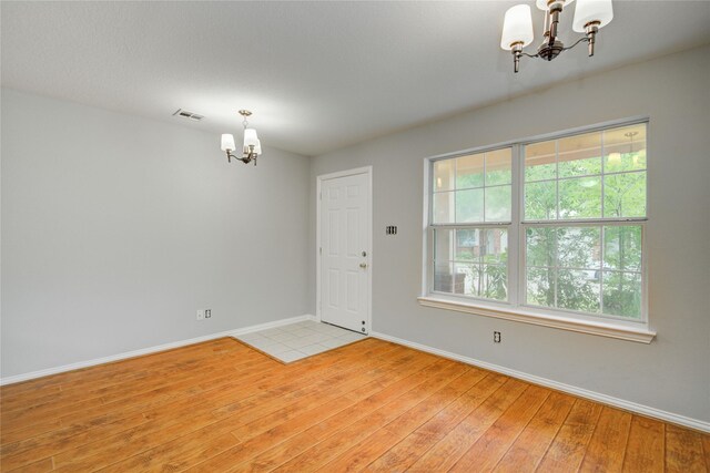 12409 Urban Dale Ct, Houston, TX 77082 - spare room featuring a chandelier, light wood-type flooring, and baseboards