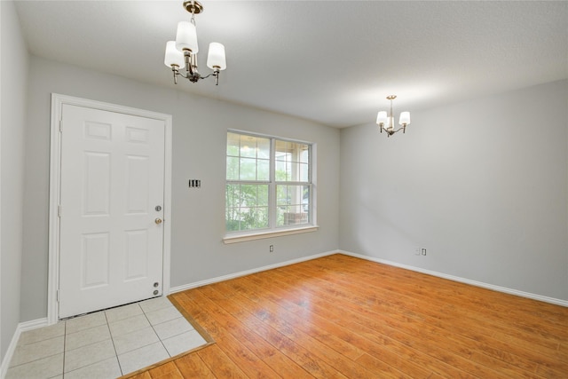 12409 Urban Dale Ct, Houston, TX 77082 - foyer with a chandelier, baseboards, and light wood-type flooring