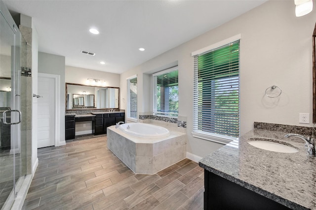 18323 Parkview Point Dr, Houston, TX 77094 - bathroom with a stall shower, two vanities, a bath, wood finished floors, and baseboards